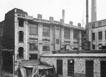 Die Alte Schmiede dicht eingepackt in die vom Krieg ramponierte Fabrik
